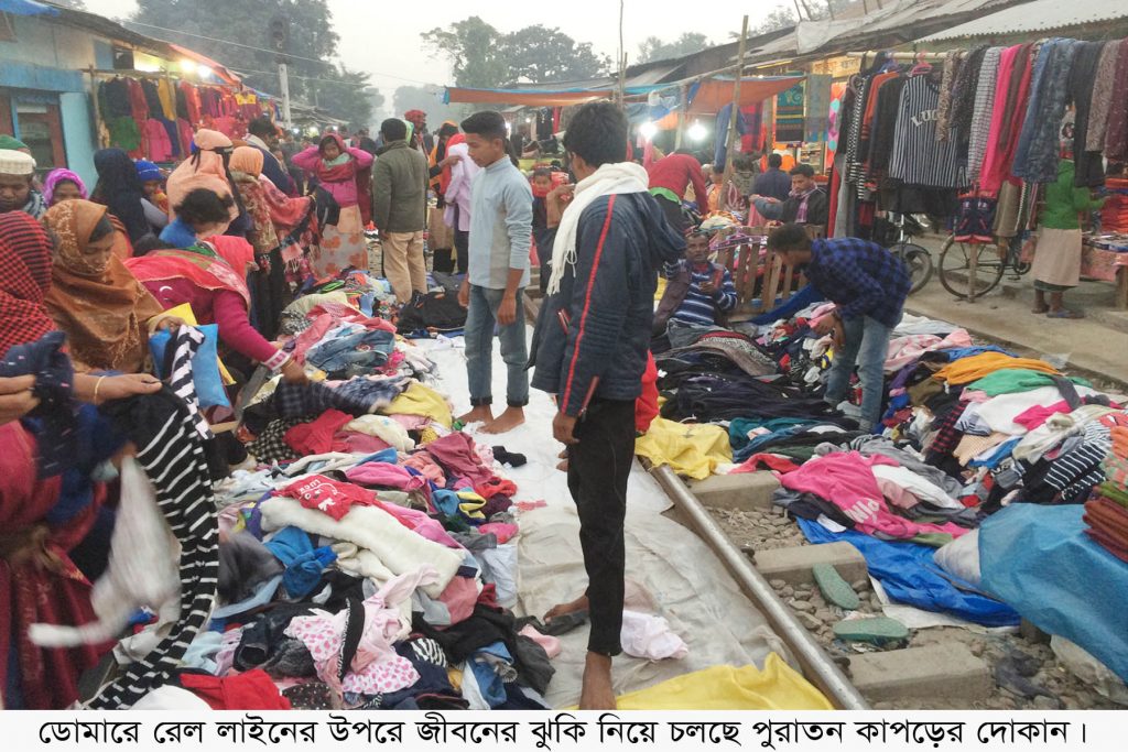 ডোমারে রেল লাইনের উপরে জীবনের ঝুঁকি নিয়ে চলছে পুরাতন কাপড়ের দোকান